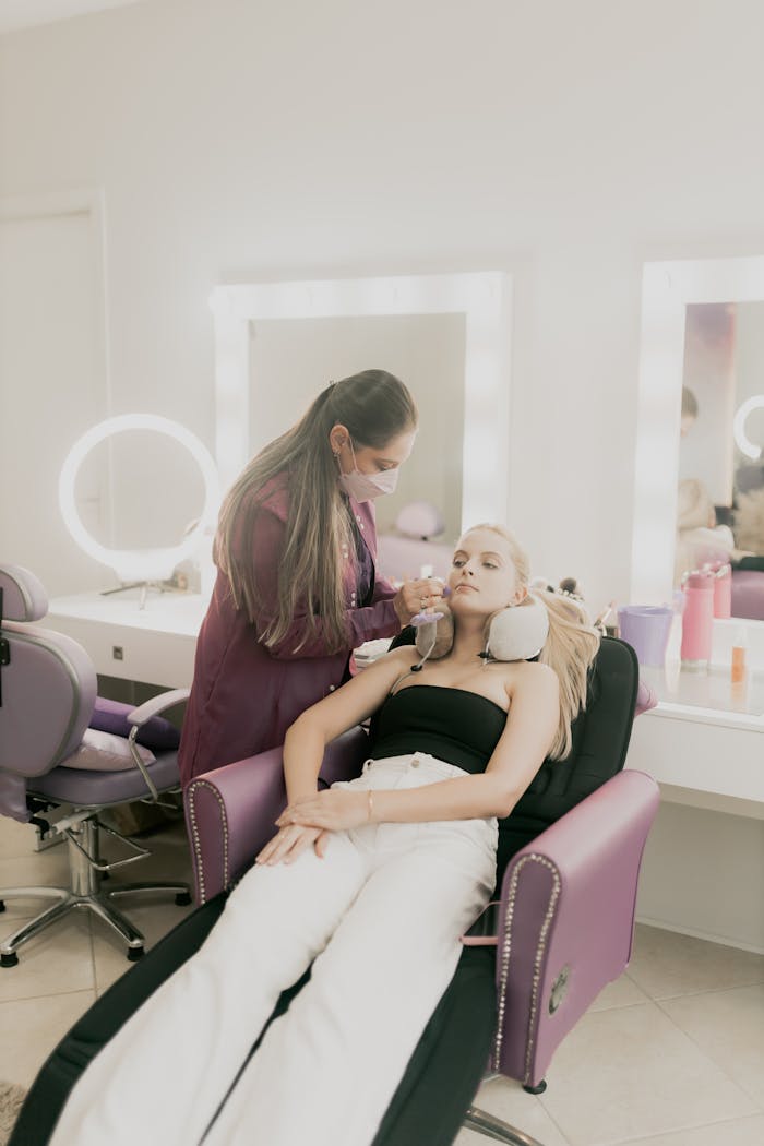 about-img A makeup artist applies cosmetics to a woman in a beauty salon.