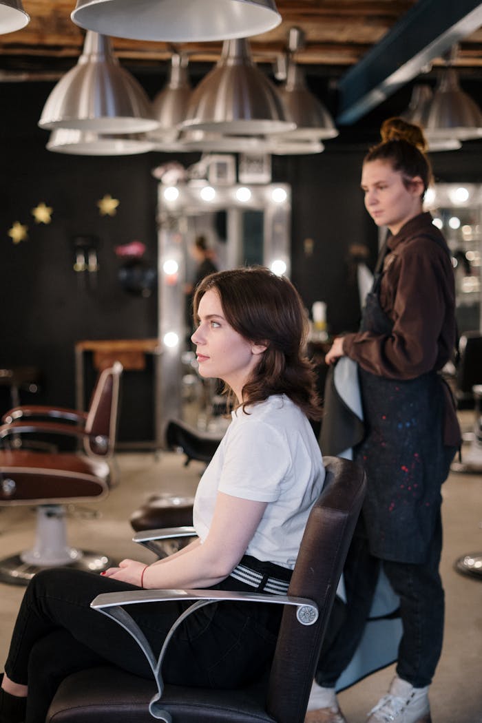 ours-journey Woman receiving a haircut in a modern salon, stylist in focus.