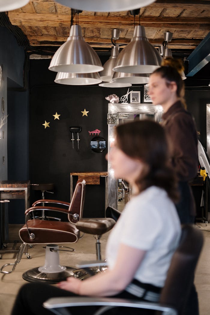 about-02 A hair stylist attends to a client in a modern and stylish salon interior.