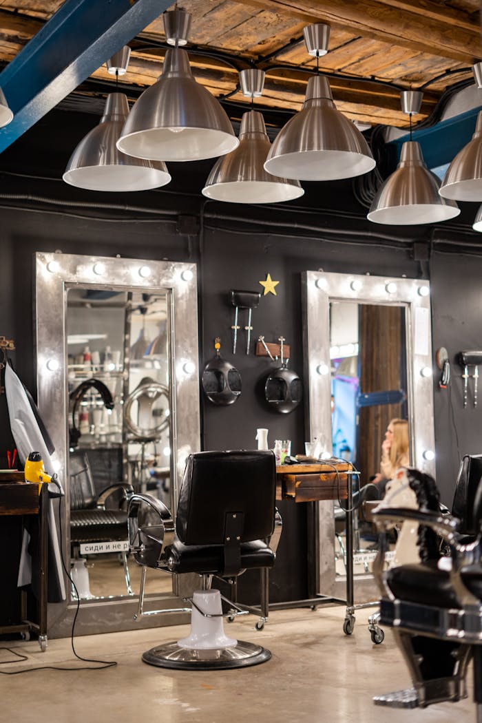 gallery-6 Cozy and stylish hair salon interior featuring chairs and illuminated mirrors.